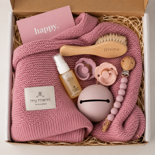 Rosa babybox från BYMINI med stickad babyfilt, nappar, nappfodral, napphållare, babyolja och hårborste